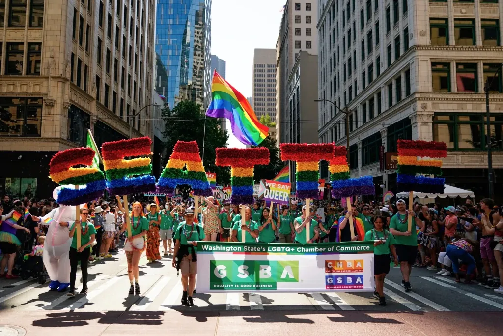 Marchers with the Greater Seattle Business Association, Washington State's LGBTQ+ and allied chamber of commerce, hold rainbow letters spelling out "Seattle," during the annual Seattle Pride Parade, June 25, 2023, in Seattle. (AP Photo/Lindsey Wasson, File)